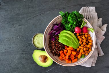 Rapini, kinoa, tatlı patates, nohut ve avokado ile sağlıklı Buda kasesi. Kırsal ahşap arkaplan üzerindeki üst görünüm.