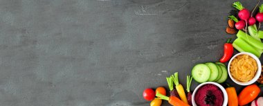 Taze sebze ve humus çeşitleri. Koyu bir afiş arkaplan üzerinde köşe kenarlığının üzerinde.