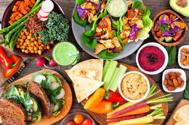 Besleyici Buda kasesi, salata, sebze, sandviç ve salata ile sağlıklı yemek masası sahnesi. Ahşap bir arkaplan üzerinde görünüm.