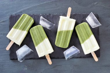 Sağlıklı yeşil buzlu içecek sunucuda buzlu şekerleme, taştan bir arka planda genel görünüm