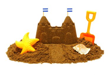 Beyaz arka planda izole edilmiş çocuk plaj oyuncaklarıyla kumdan kale