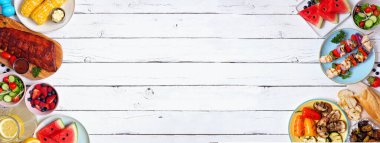 Yaz barbeküsü ya da piknik yemekleri çifte sınır. Izgara et, sebze, meyve, salata ve patates. Beyaz ahşap bir arkaplanda manzaranın üstünde. Boşluğu kopyala.