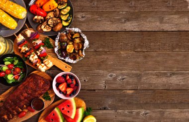 Yaz mangalı ya da piknik kenarı kırsal bir arka planda. Izgara et, sebze, meyve, salata ve patates. Kopyalama alanı olan üst görünüm.
