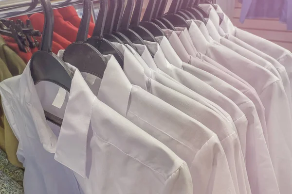 White men\'s shirts on hangers