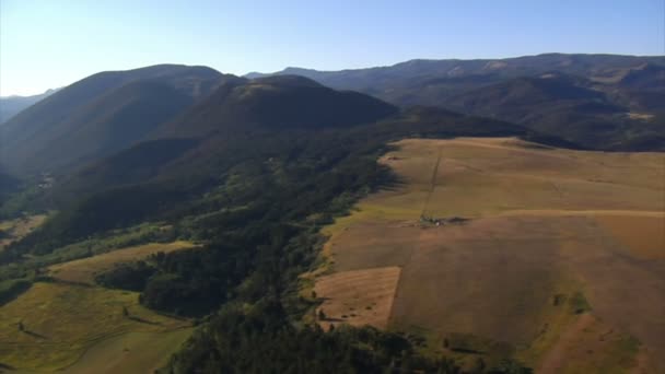 Aerial shot of forest and mountainside and fields — Stock Video
