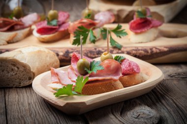 Tapas dilimlenmiş sosis, salam, zeytin ve maydanoz ile.