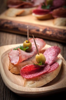 Tapas dilimlenmiş sosis, salam, zeytin ve maydanoz ile.