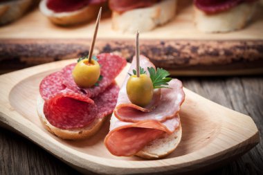 Tapas dilimlenmiş sosis, salam, zeytin ve maydanoz ile.