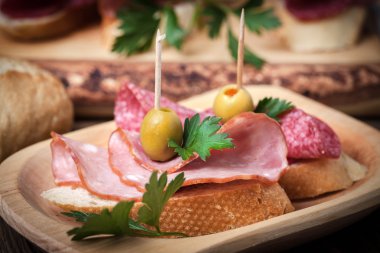 Tapas dilimlenmiş sosis, salam, zeytin ve maydanoz ile.