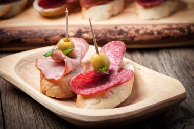 Tapas dilimlenmiş sosis, salam, zeytin ve maydanoz ile.