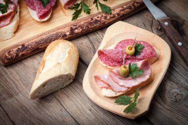 Tapas dilimlenmiş sosis, salam, zeytin ve maydanoz ile.