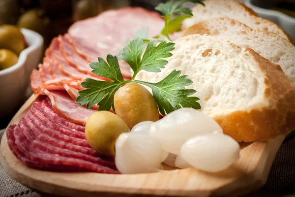 Tapas i plasterki kiełbasa, salami, oliwki, marynowane cebule, cuc — Zdjęcie stockowe