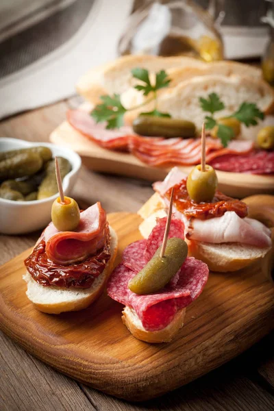 Tapas con salchichas en rodajas, salami, aceitunas y perejil . Fotos De Stock Sin Royalties Gratis