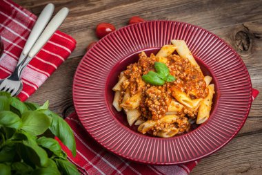 Penne bolognese beyaz plaka üzerinde.