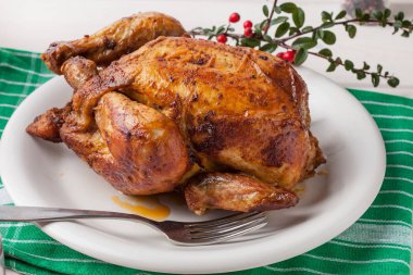 Beyaz plaka üzerinde pişmiş tavuk.