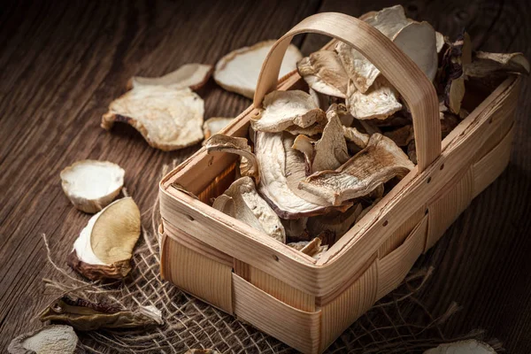 Cogumelos secos em uma cesta de madeira . — Fotografia de Stock