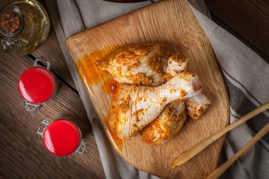 Ahşap doğrama tahtası üzerinde marine edilmiş tavuk sopaları.