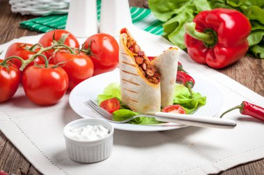 Kıyılmış et, fasulye ve sebze dolu burrito.