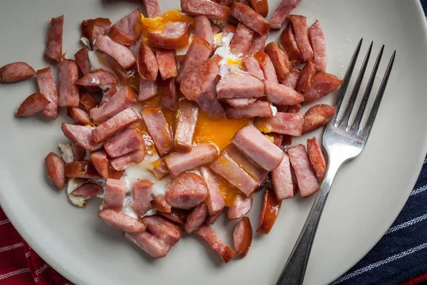 Pieces of sausage fried with egg. — Stock Photo, Image