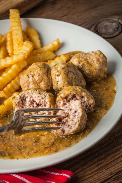 Meatballs with french fries in dill sauce. — Stock Photo, Image