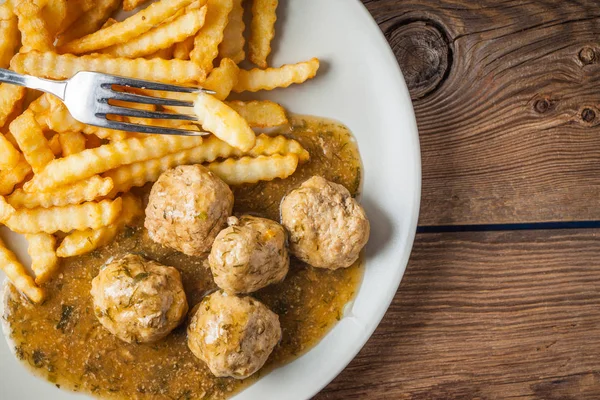 Meatballs with french fries in dill sauce. — Stock Photo, Image