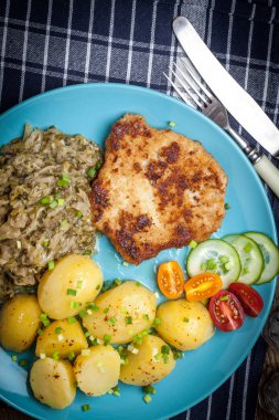 Kızarmış domuz eti, fırında patates ve kızarmış genç lahana.