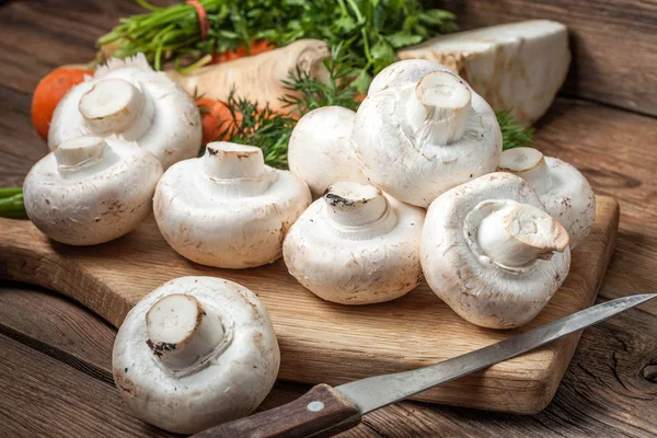 Funghi di Champignon su un tagliere di legno — Foto Stock