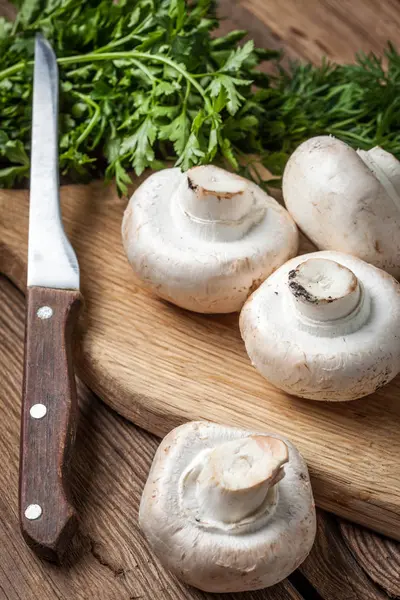 Funghi di Champignon su un tagliere di legno — Foto Stock