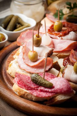 Tapas dilimlenmiş sosis, salam, zeytin ve maydanoz ile.