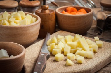 Ahşap doğrama tahtası üzerinde doğranmış patates.