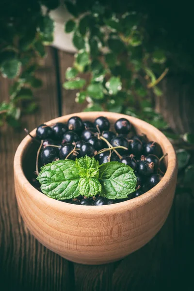 Blackcurrant in wooden bowl. — Stock Photo, Image