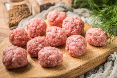 Tahta kesme tahtasının üzerinde çiğ köfteler..