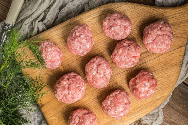 Raw meatballs on the wooden cutting board. — Stock Photo, Image