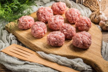 Tahta kesme tahtasının üzerinde çiğ köfteler..