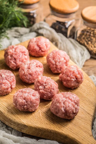 Raw meatballs on the wooden cutting board. — Stock Photo, Image