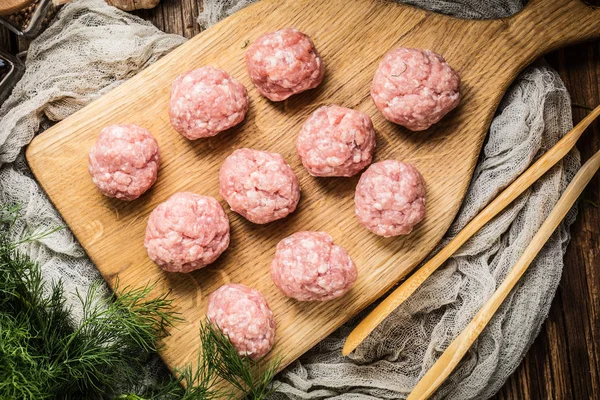 Raw meatballs on the wooden cutting board. — Stock Photo, Image