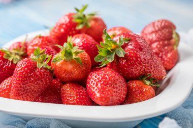 Olgun kırmızı çilek beyaz kase.