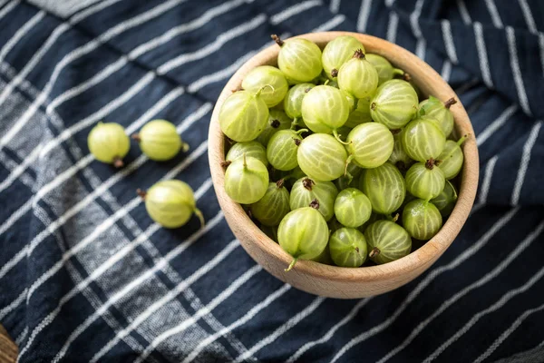 Fresh gooseberry in a wooden bowl. — Stock Photo, Image