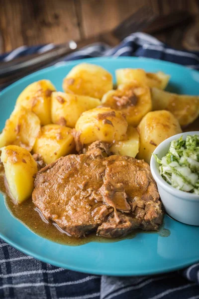 Braised meat in sauce served with boiled potatoes.