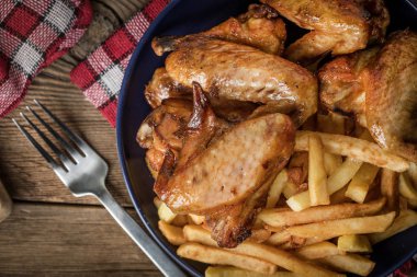 Fırında tavuk kanadı patates kızartması ile.