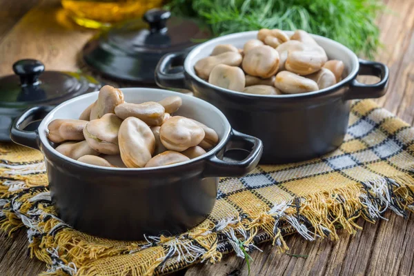 Saubohnen in schwarzen Schalen serviert. — Stockfoto