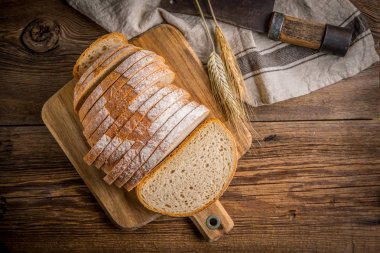 Bir kesme tahtası üzerinde ekmek dilimlenmiş. 