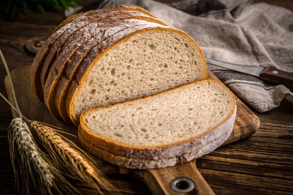 Bir kesme tahtası üzerinde ekmek dilimlenmiş. 