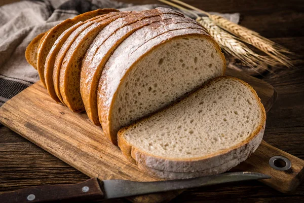 Bir kesme tahtası üzerinde ekmek dilimlenmiş. 