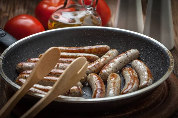 Fried white sausages in a cast iron skillet. — Stock Photo, Image