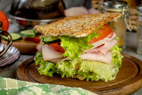 Бутерброд з шинкою, огірком, помідорами та салатом . — стокове фото