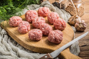 Tahta kesme tahtasının üzerinde çiğ köfteler..