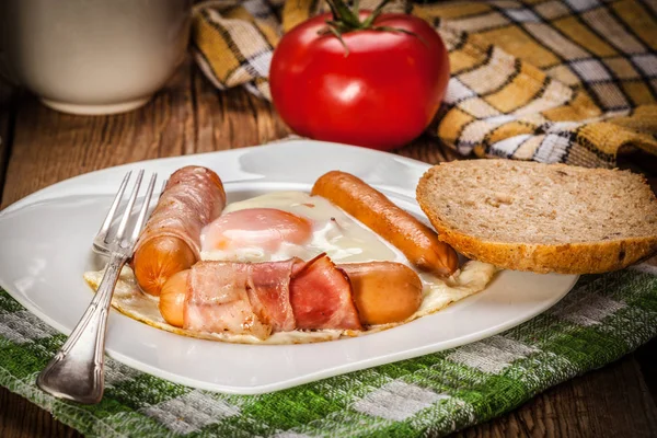 Ovos fritos com salsichas e bacon . — Fotografia de Stock