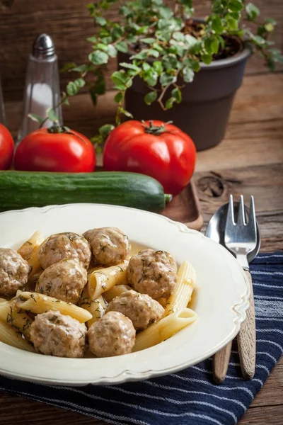 Pork meatballs with dill sauce and pasta. — Stock Photo, Image