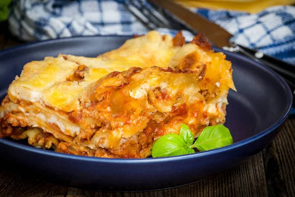 Pezzo di gustose lasagne calde con vino rosso. — Foto Stock